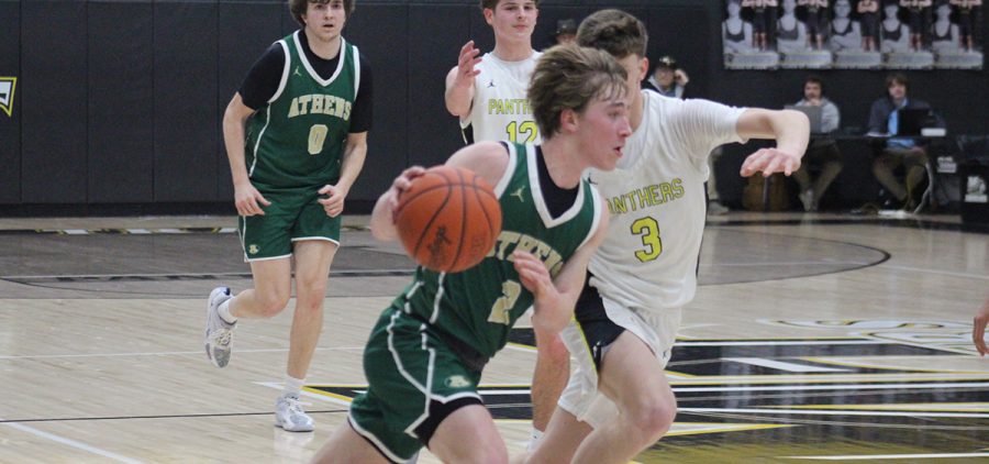 The Athens player drives the ball towards the paint, trying to score on the Miami Trace defender.