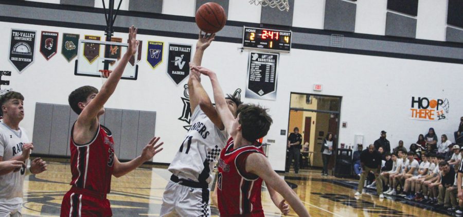 River Valley player goes up for a tough layup between two Alexander defenders.