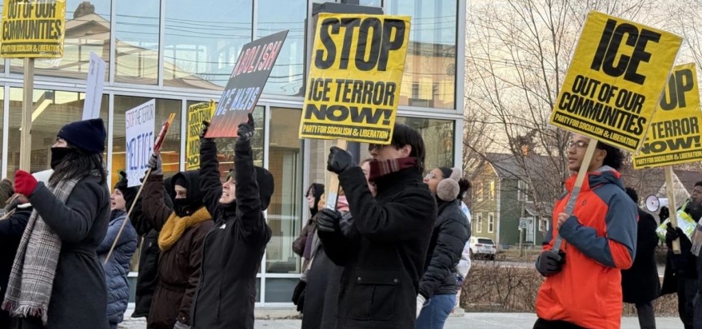 People hold signs protesting ICE