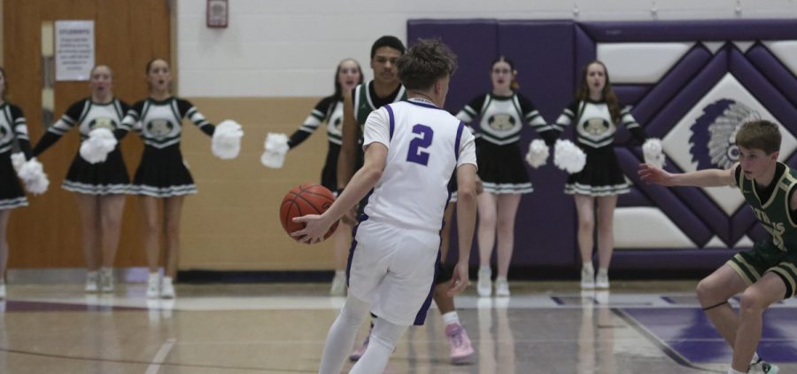 Logan player dribbles the ball up the court with an Athens defender waiting.