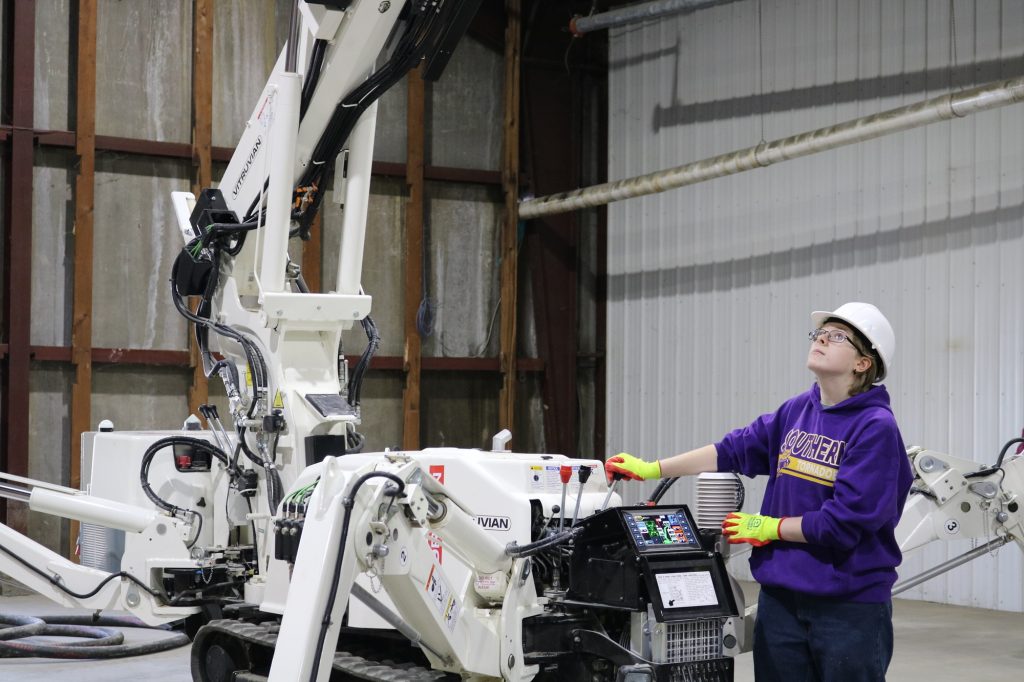 Southern Local junior Sophie Popp practices moving the printing head of Vitruvian's 3D printer, used for building houses.