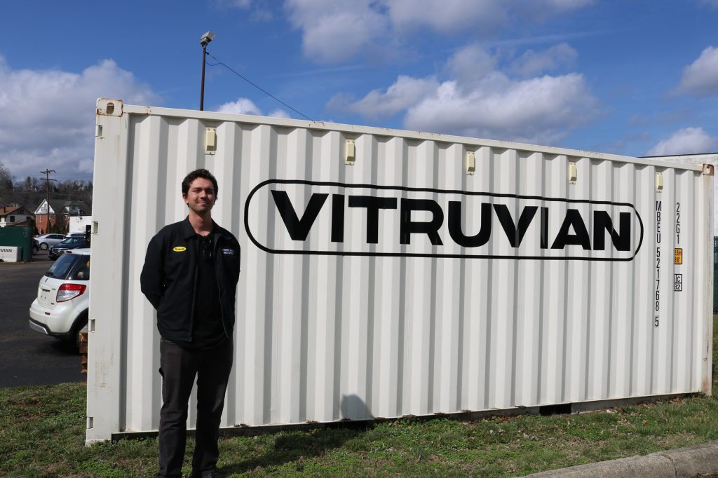 Stefano Alvo stands in front of a Vitruvian shipping crate.