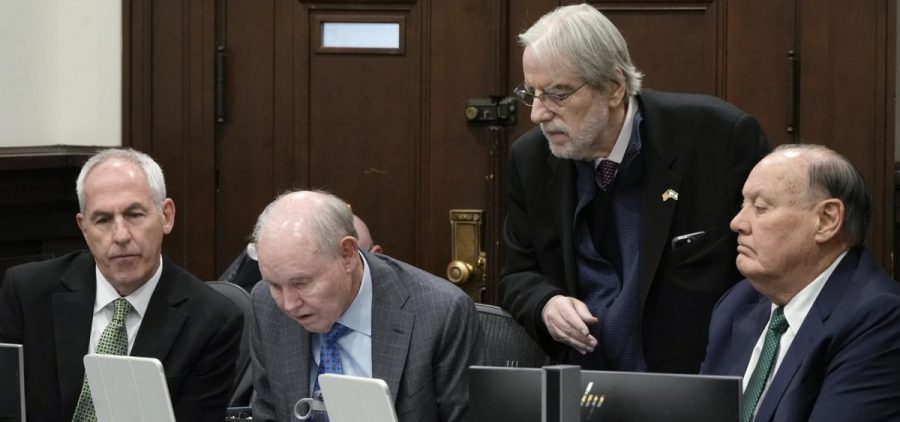 Ex-FirstEnergy Senior Vice President Michael Dowling, defense attorneys Dan Webb, William Sherman and former FirstEnergy CEO Chuck Jones look over a transcript as as the parties adjourn for an in chambers conference during the State’s rebuttal in their trial in Summit County Common Pleas Judge Susan Baker Ross's courtroom in Akron
