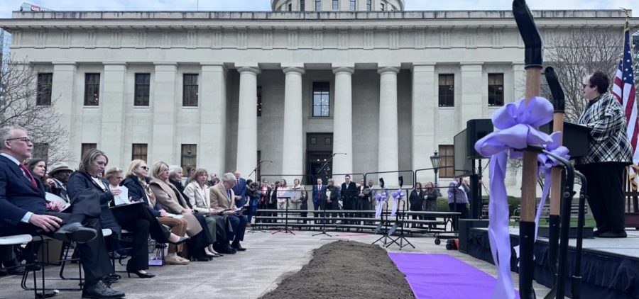 Donna Collins with the Ohio Arts Council speaks at the event celebrating the Women's Monument on March 25, 2026. Honorees used shovels with purple bows to turn over the dirt for the ceremonial groundbreaking.