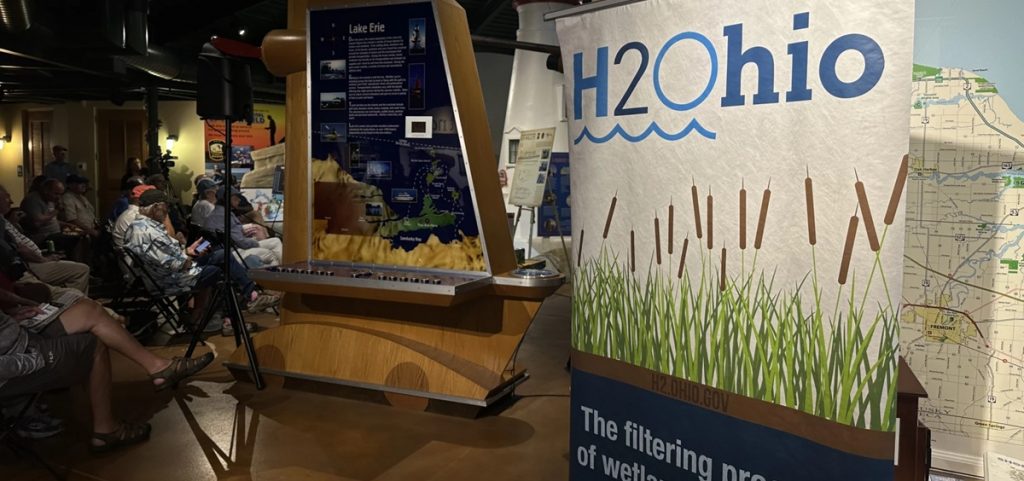 An H2Ohio sign sits in front of a crowd gathered for Fish Ohio Day.