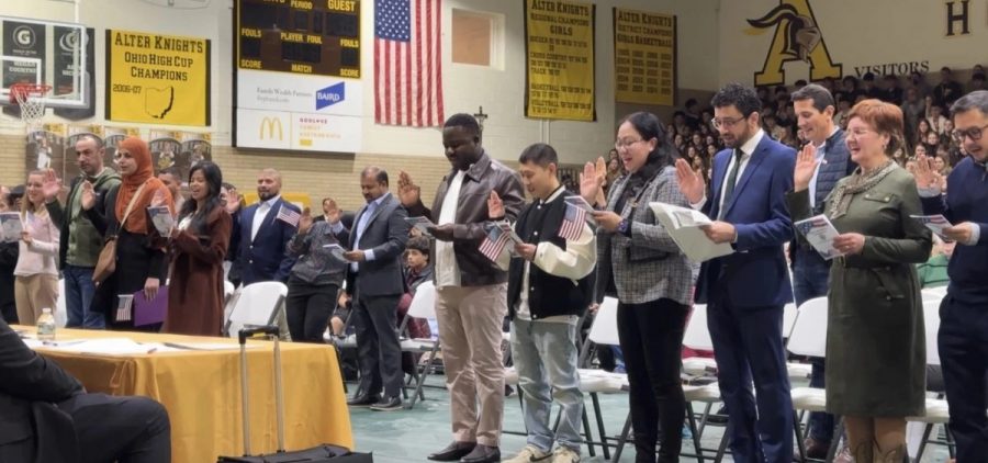 People holding their hand up while giving Oath of Allegiance, the final step to giving citizenship at a ceremony in Kettering