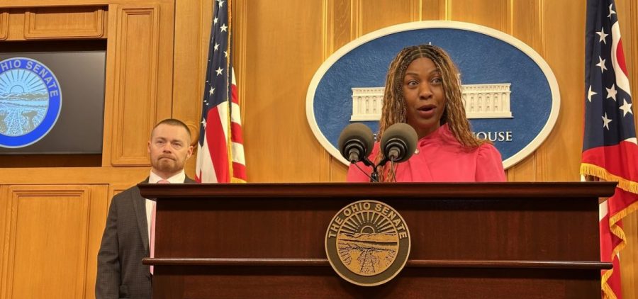Beau Buzbee and Sen. Michele Reynolds stand at a podium.