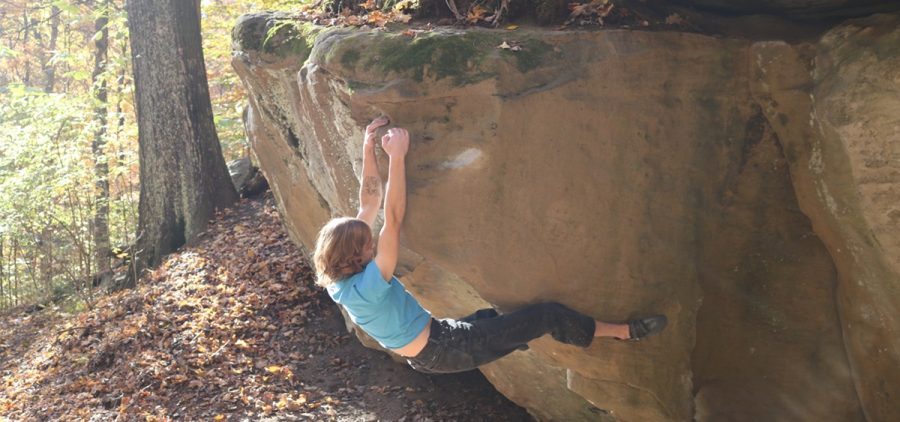 Ohio University freshman Alex Beasley hangs upside down from a rock in Strouds Run State Park.