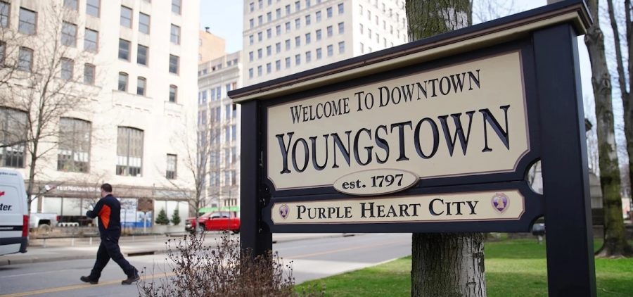 A sign in front of a city backdrop welcomes people to downtown Youngstown.