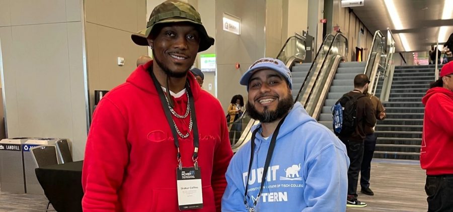 Two men stand next to each other and pose for a picture.