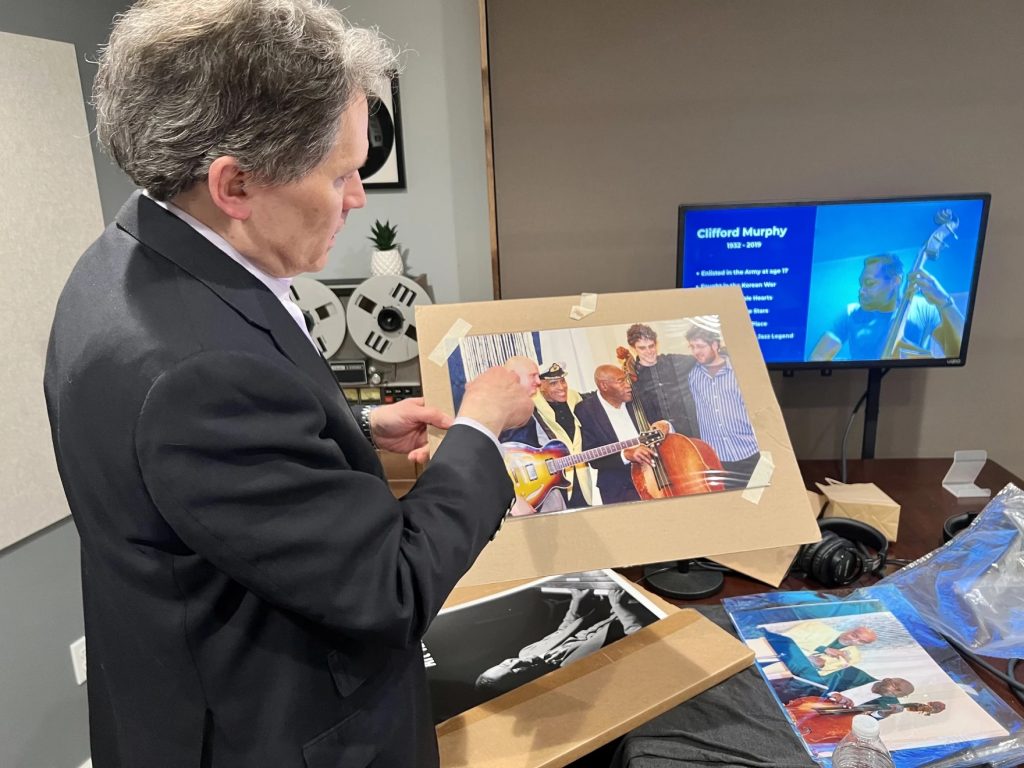 Jazz historian Doug Swiatecki pulls out a photo of Cliff Murphy, alongside other jazz greats.