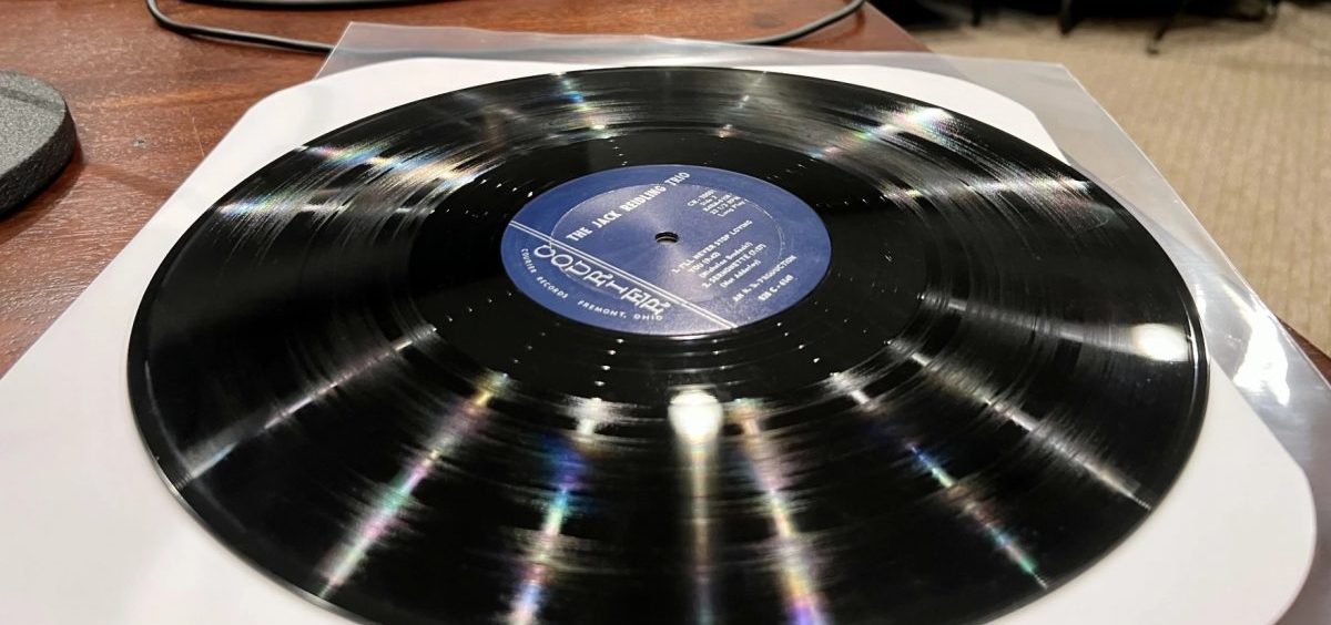A vinyl record sits on top of a paper sleeve.