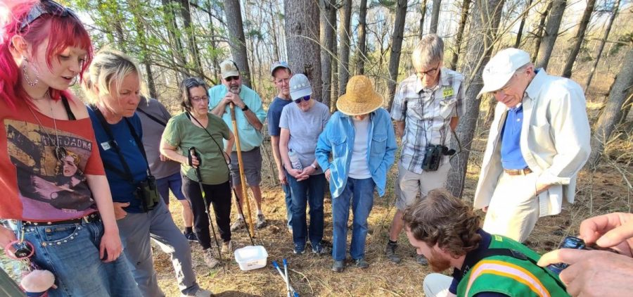 Fernald's Luke Thies (wearing a green vest) leads a tour group looking for salamanders.