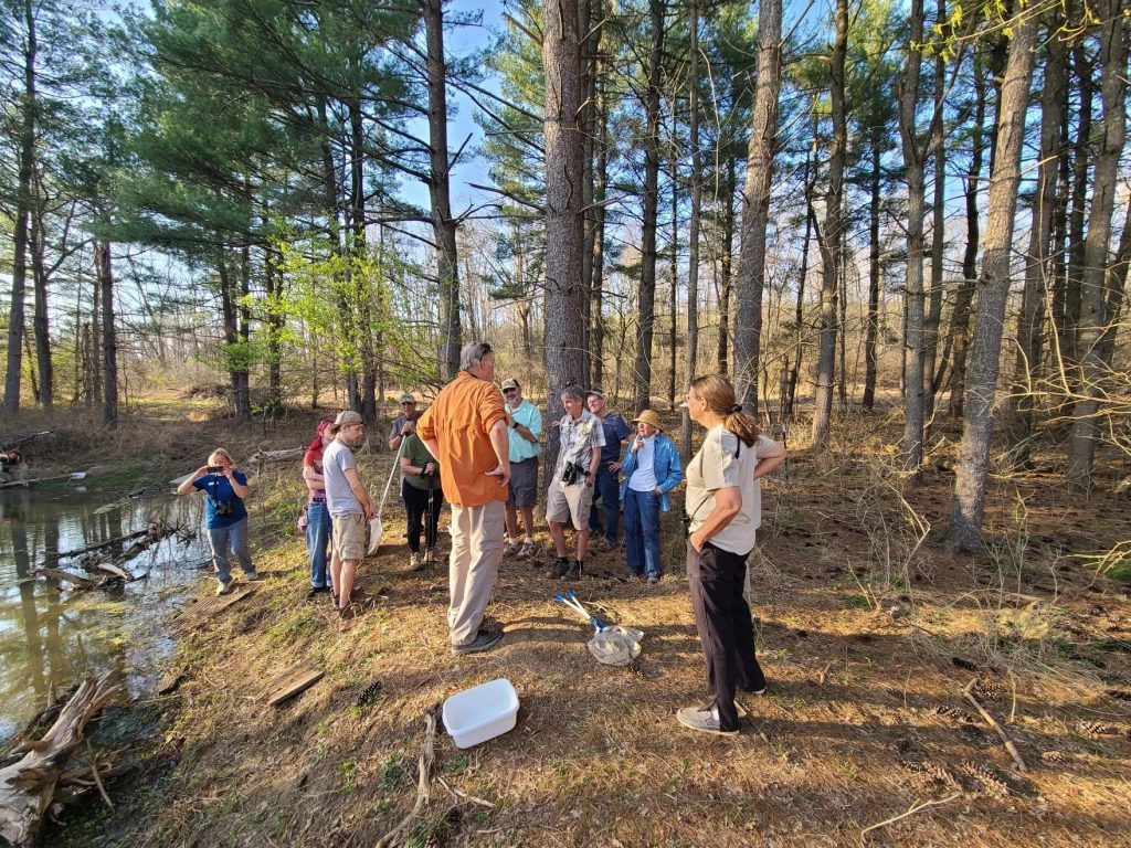 Herpetologist Jeff Davis (center in burnt orange shirt) discusses salamanders during a recent tour of Fernald Preserve.