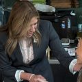Democratic gubernatorial candidate Amy Acton shakes a seated woman's hand in a cafe.