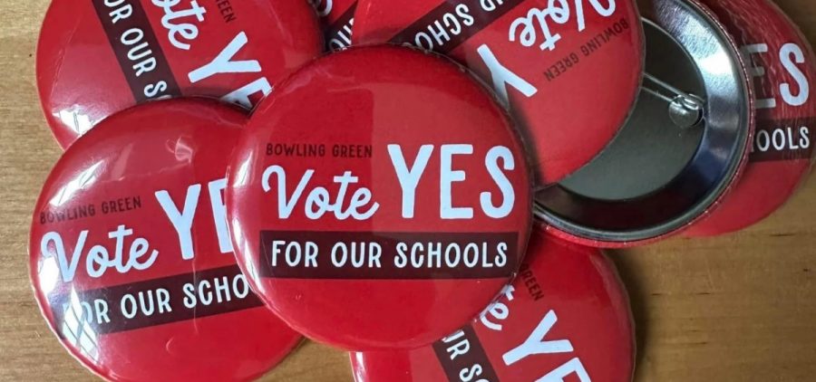 A pile of buttons on a table that read Bowling Green Vote Yes For Our Schools