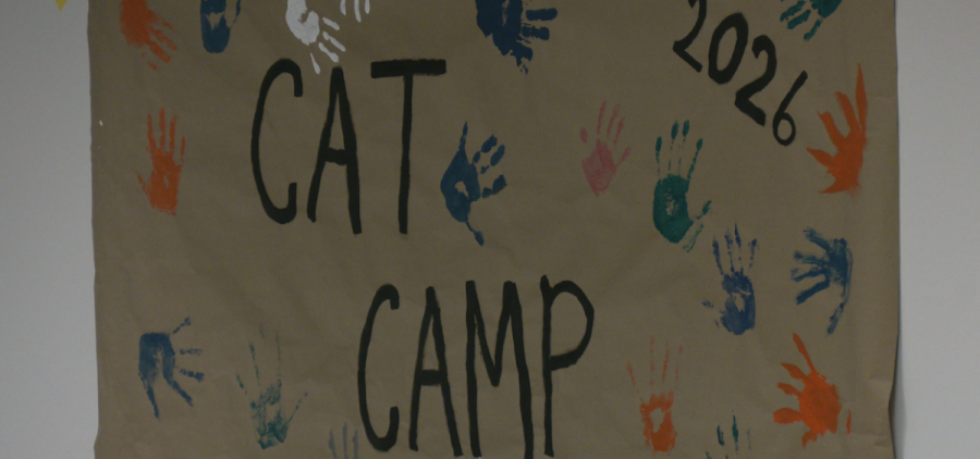 A banner with handprints painted on reads Cat Camp 2026