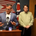 Ohio Attorney General Andy Wilson speaks at a podium during a press conference with Vinton County Prosecutor William Archer and Vinton County Sheriff Ryan Cain.