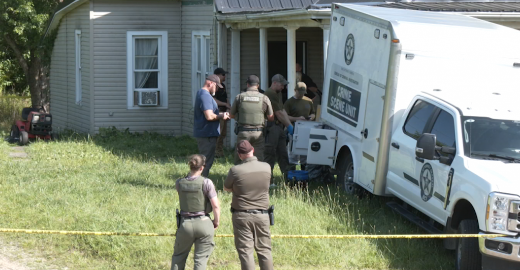 Law enforcement officers gather outside a home in Vinton County where four people were arrested Tuesday on charges of child endangerment.
