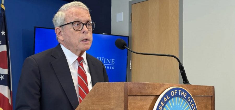 Gov. Mike DeWine stands at a podium.