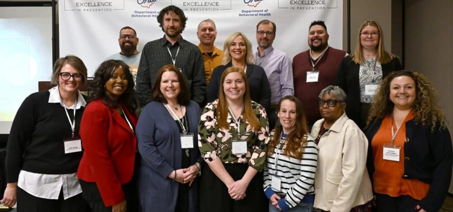 A group of people stand in two rows for a group picture.