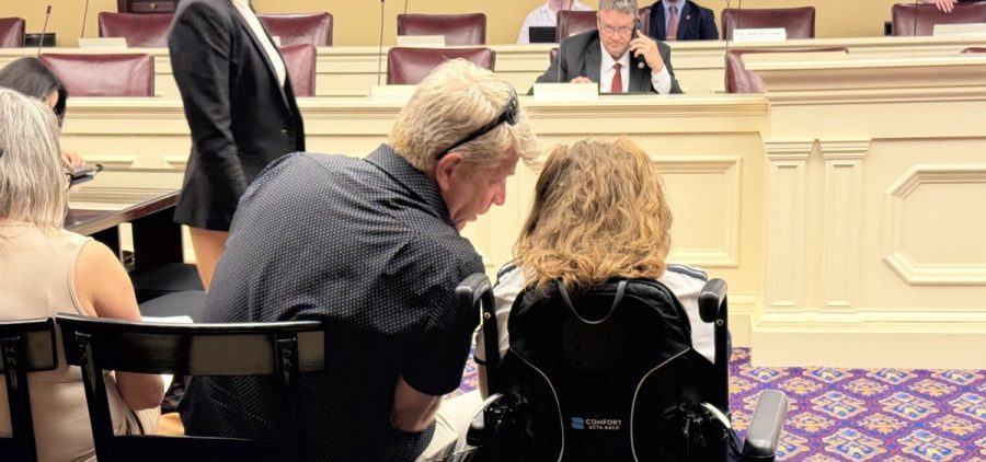 A father and daughter in a wheelchair are among those gathered at the Ohio Statehouse during a hearing on Medicaid reforms at the statehouse.