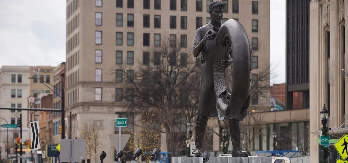 A statue of a man holding a tire is seen in Akron.