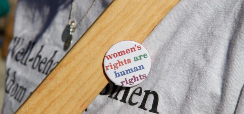 A button at a women's rights march reads women's rights are human rights
