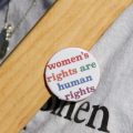 A button at a women's rights march reads women's rights are human rights