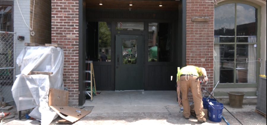 A worker applies some finishing touches to the entrance of The Mine Tavern, which underwent a monthslong rehabilitation after a partial collapse in February.