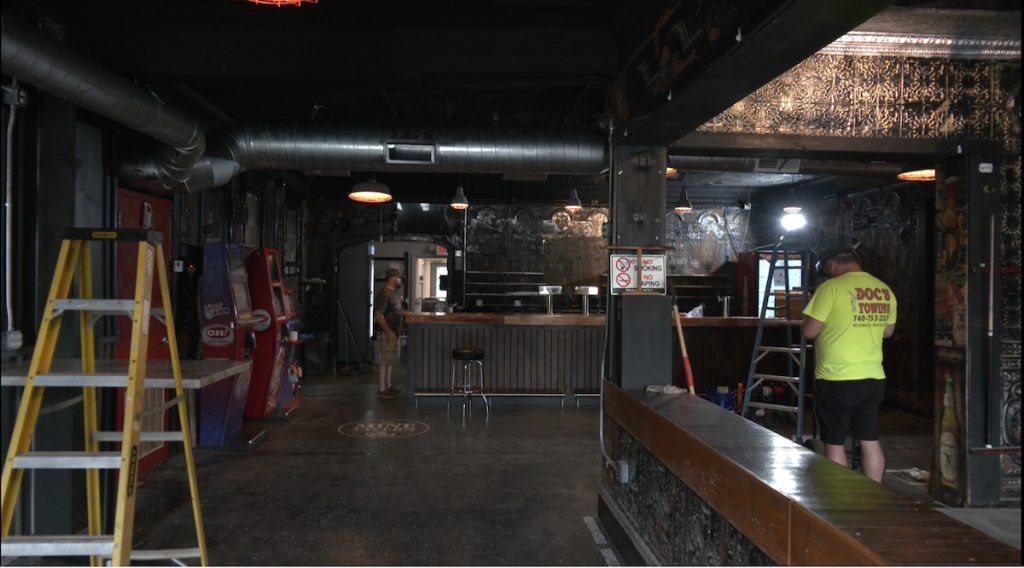 Workers apply finishing touches to the interior of The Mine Tavern in Nelsonville, which underwent months of restoration following a partial collapse earlier this year.