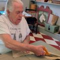 Paul Brennan cuts fabric inside the 18th century tailor shop at his home in Jerusalem, Ohio.