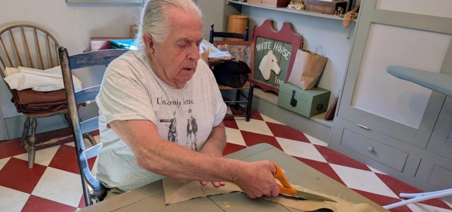 Paul Brennan cuts fabric inside the 18th century tailor shop at his home in Jerusalem, Ohio.