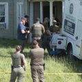 Law enforcement officers gather outside a home in Vinton County where four people were arrested on charges of child endangerment.