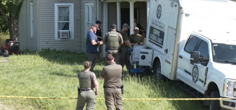 Law enforcement officers gather outside a home in Vinton County where four people were arrested on charges of child endangerment.