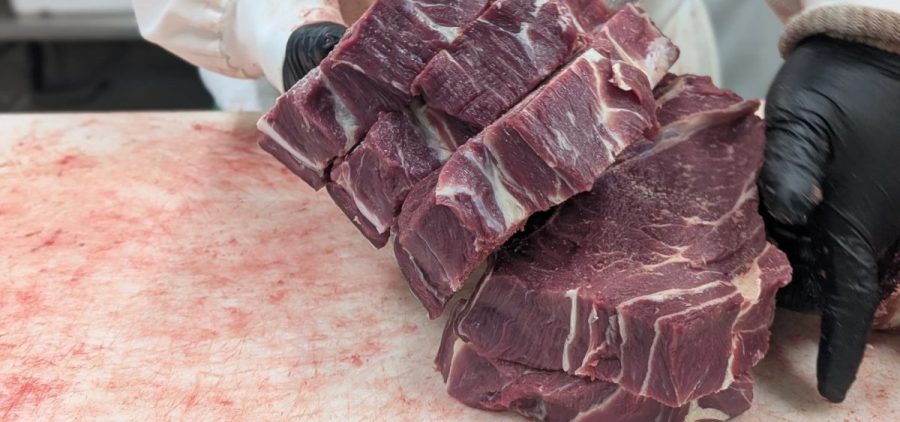 Chase Meeks organizes cuts of beef for a customer's order.