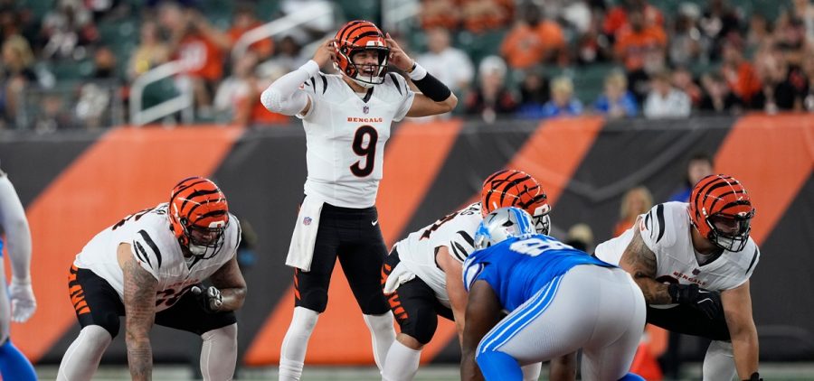 Cincinnati Bengals quarterback Joe Burrow (9) signals at the line of scrimmage against the Detroit Lions during the first half of a preseason NFL football game
