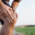 Sporty man in pain after sustaining a knee injury during a run