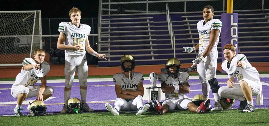 A group of Athens Bulldogs pose for a photo with a trophy after their rivalry game against Logan High School
