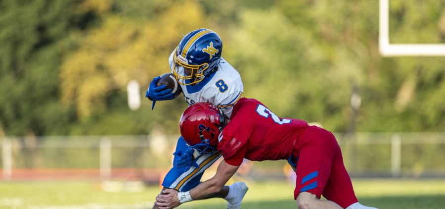 West Muskingum wide receiver tries to break a tackle by a Fort Frye defender.