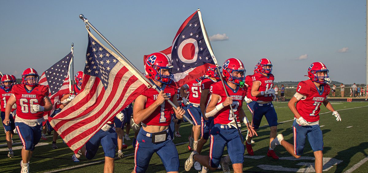 Licking Valley runs out with flags before their week one matchup against Sheridan.