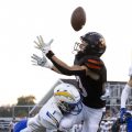 A Panthers receiver tries to catch a ball while getting tackled by a Philo defender.
