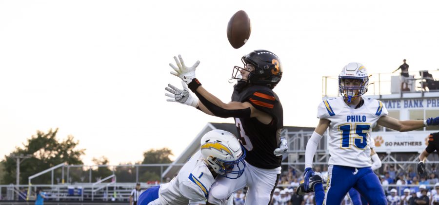 A Panthers receiver tries to catch a ball while getting tackled by a Philo defender.