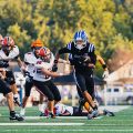 Cartae Ligon carrying the ball, weaving to get past Wheelersburg players as they try to tackle him.