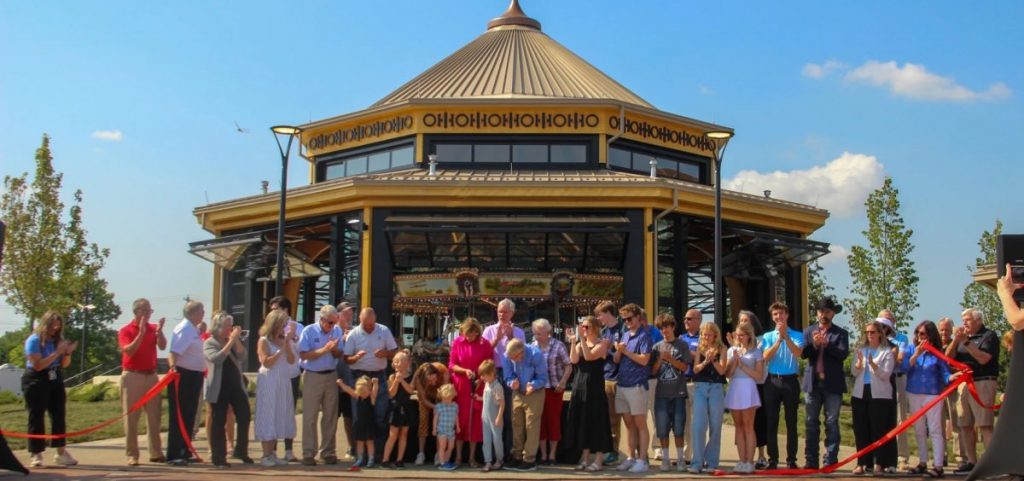 Governor Mike DeWine and his wife, Fran, center, cut a ribbon to open the new carousel at the Ohio State Fairgrounds