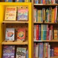Kids books sit on bookshelves in a bookstore.
