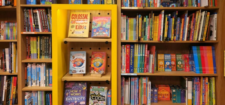 Kids books sit on bookshelves in a bookstore.