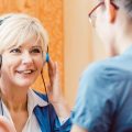 Older woman with a hearing problem takes test.