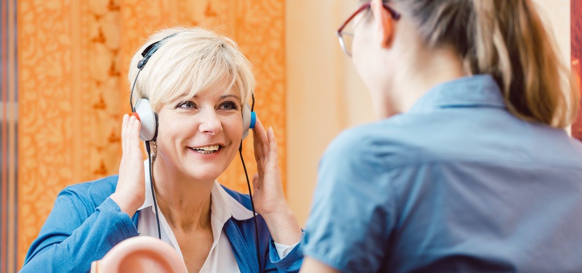 Older woman with a hearing problem takes test.