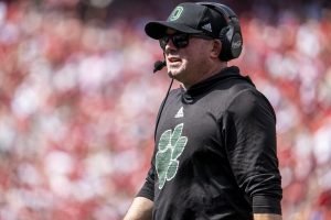 John Hauser stands with headset while coaching against Nebraska